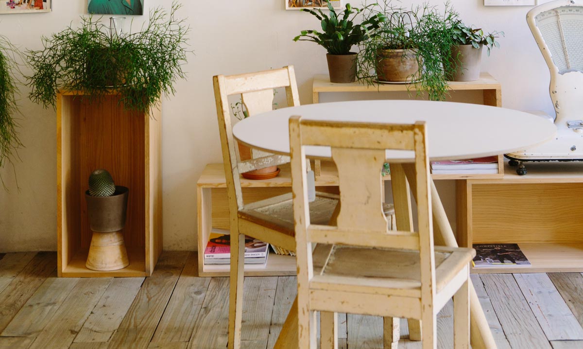 A table with chairs and plants on top of it.